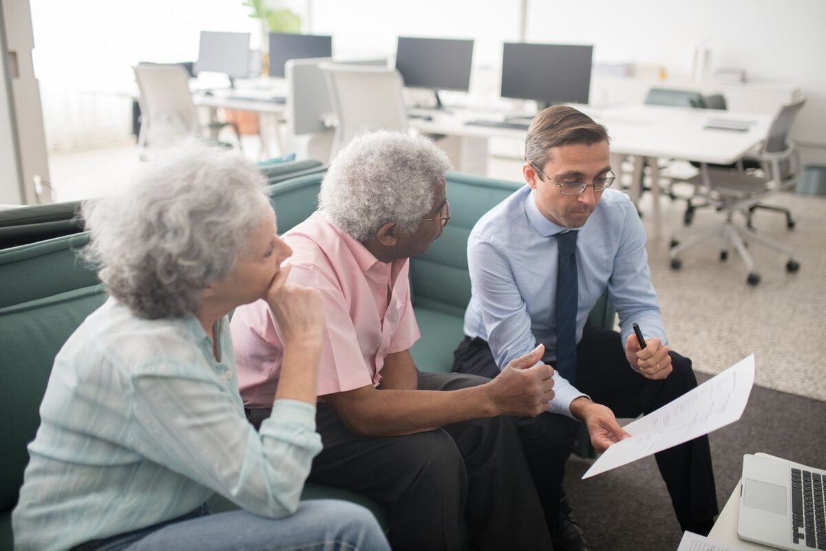 Older couple reviewing retirement account paperwork with an advisor - QDRO retirement division