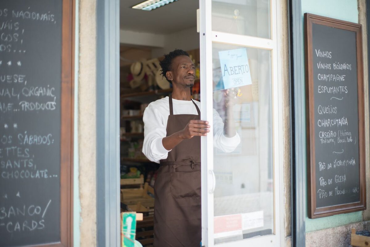 Small business owner standing at the open door of their shop - business document filing