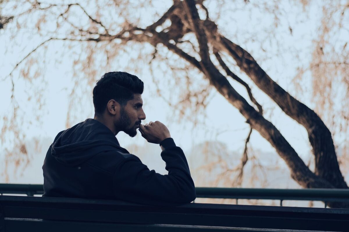 Pensive man looking out over a railing, deep in thought - the psychology of putting off estate planning