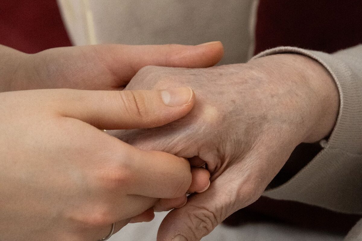 Younger hand holding an elderly family member's hand - conservatorship of the person